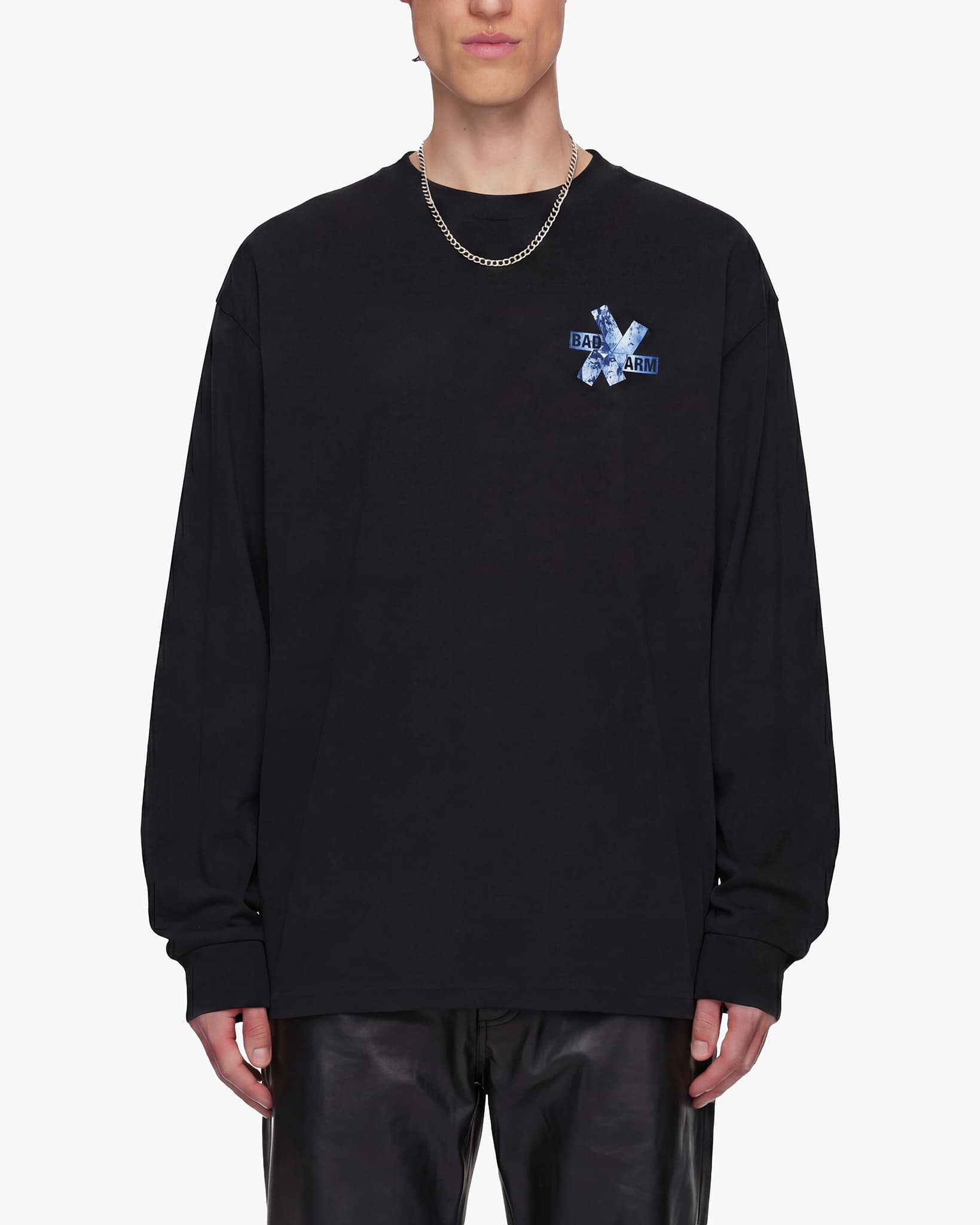 Person wearing a black long-sleeve shirt with a logo on a white background